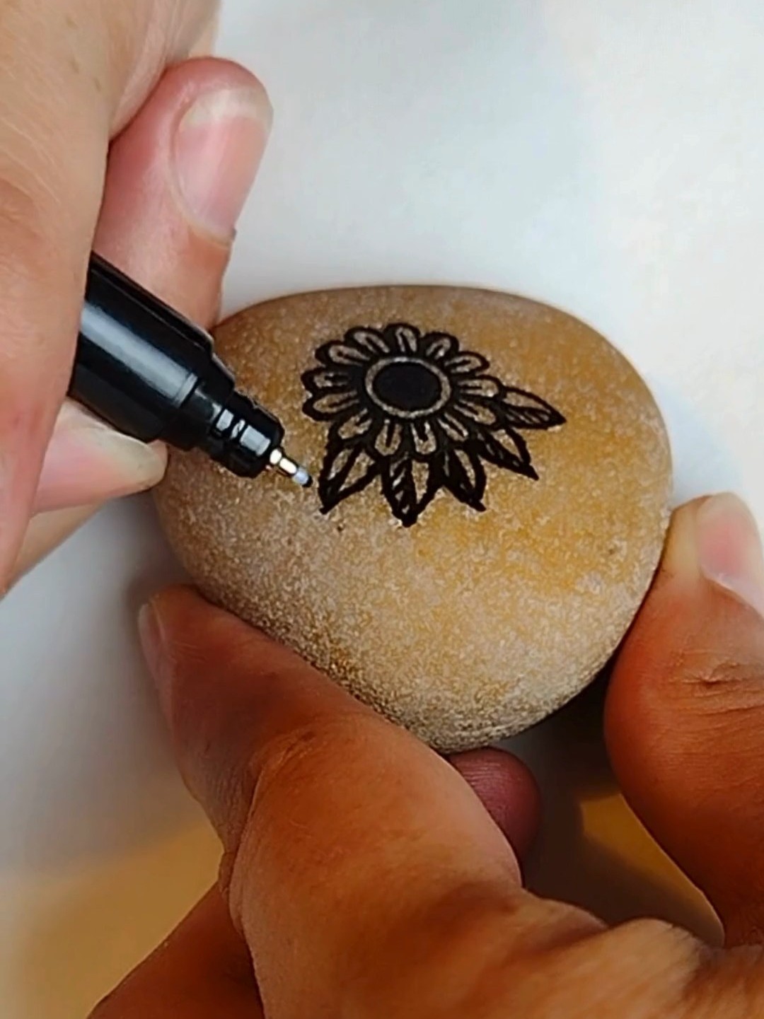 In-progress memorial rock being painted for Adam Dohr