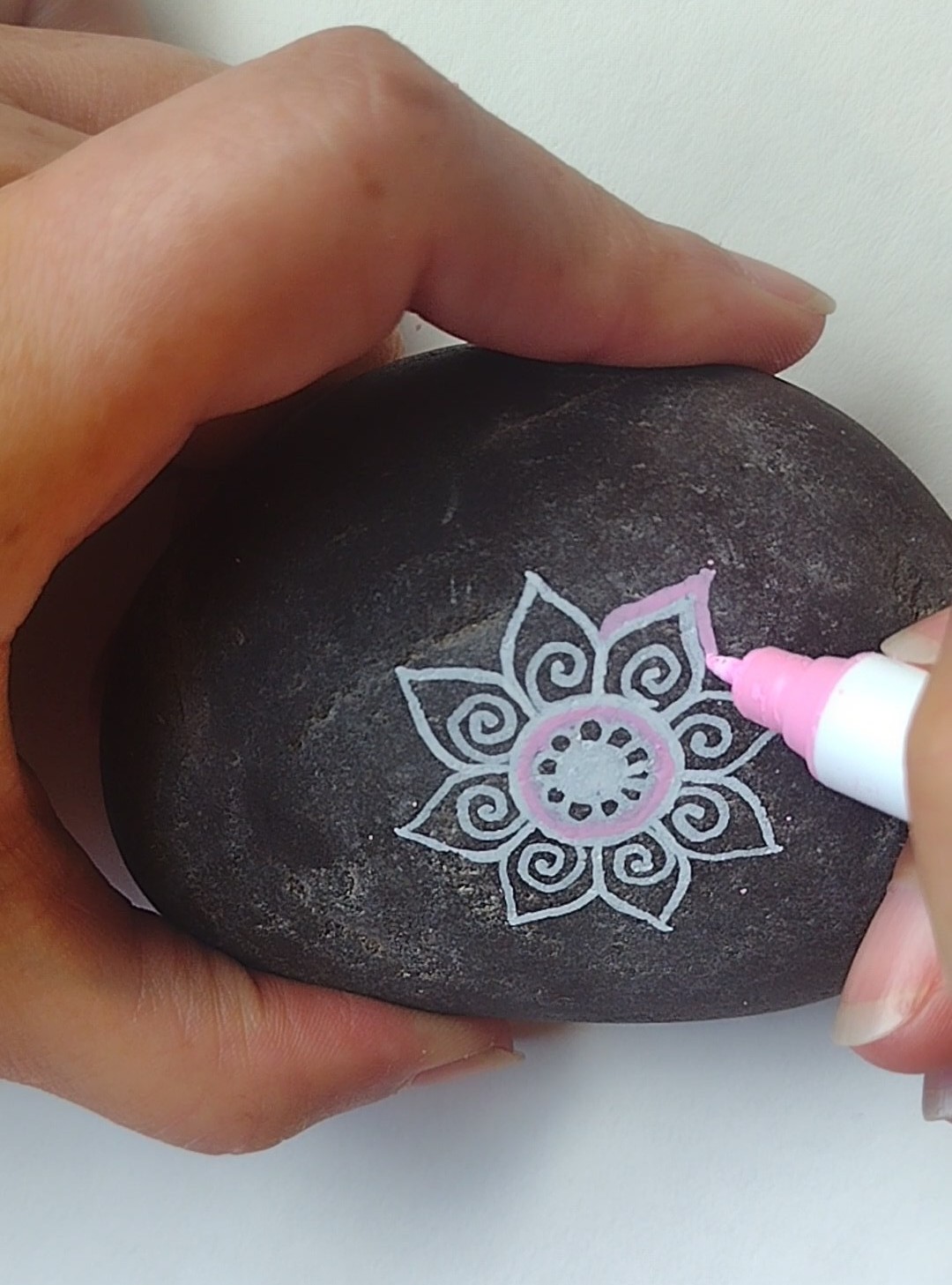 Mary Ann Whittaker memorial rock being painted with a white and pink mandala design